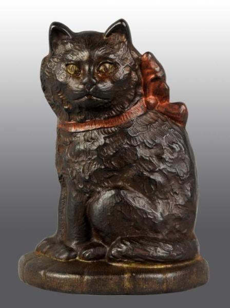 CAST IRON CAT WITH BOW ON PILLOW DOORSTOP.        