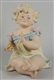 LARGE BISQUE PIANO BABY FIGURINE.                 