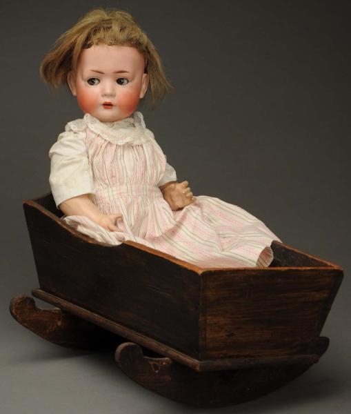 FLIRTY-EYED CHARACTER BABY WITH CRADLE.           