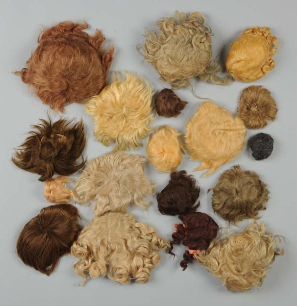 LOT OF 17 DOLL WIGS.                              