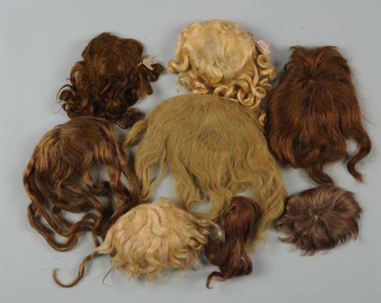 LOT OF 7 DOLL WIGS.                               