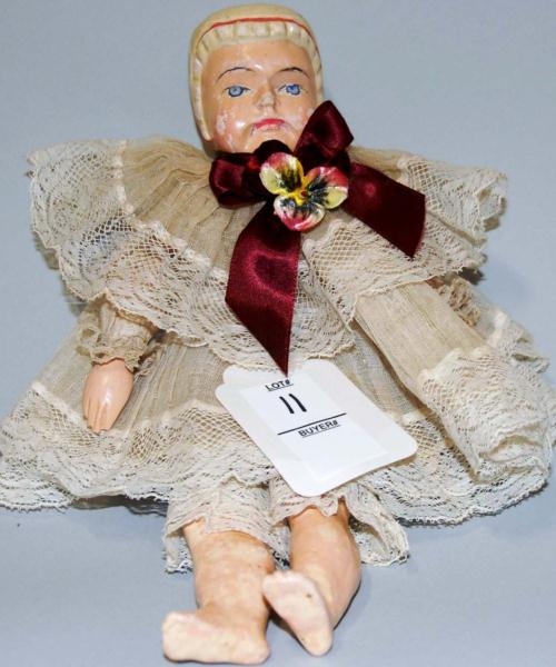 COMPOSITION DOLL WITH MAROON BOW.                 