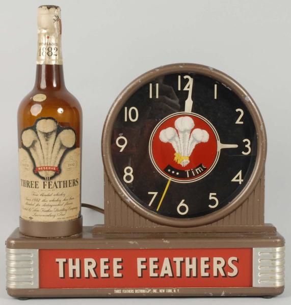THREE FEATHERS WHISKEY SPINNER CLOCK.             