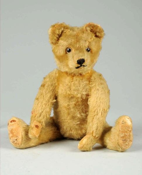 STRAW-FILLED VINTAGE JOINTED STUFFED TEDDY BEAR.  