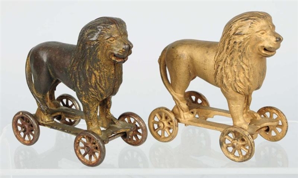 LOT OF 2: CAST IRON LION ON WHEELS BANKS.         