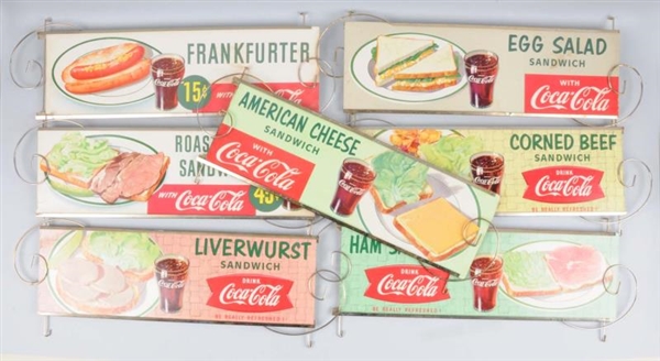 LOT OF 7: COCA-COLA CARDBOARD SIGN GROUP.         