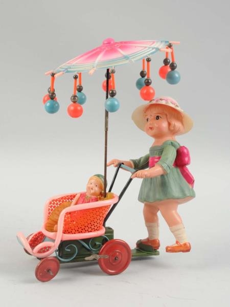 JAPANESE CELLULOID WIND UP WOMAN PUSHING STROLLER.