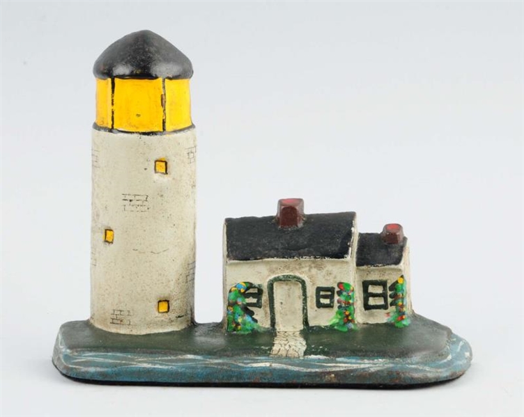CAST IRON LIGHTHOUSE WITH COTTAGE DOORSTOP.       