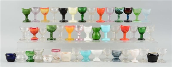 LARGE LOT OF ASSORTED GLASS EYE WASH CUPS.        