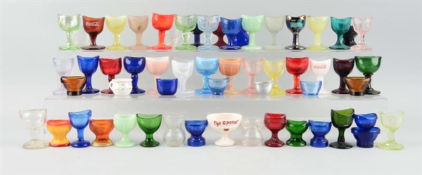 LARGE LOT OF ASSORTED GLASS EYE CUPS.             