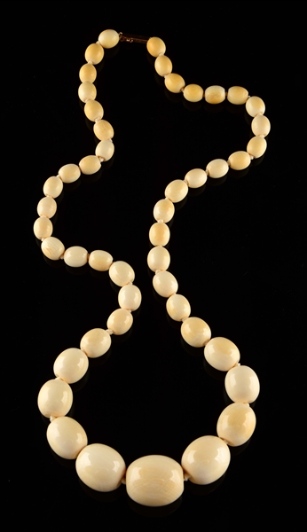 A LONG GRADUATED OVAL BEADED IVORY NECKLACE.