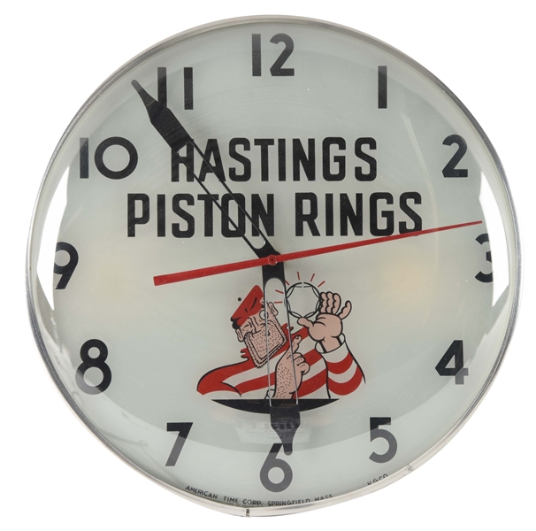 HASTING PISTON RINGS LIGHT UP GLASS FACE CLOCK. 