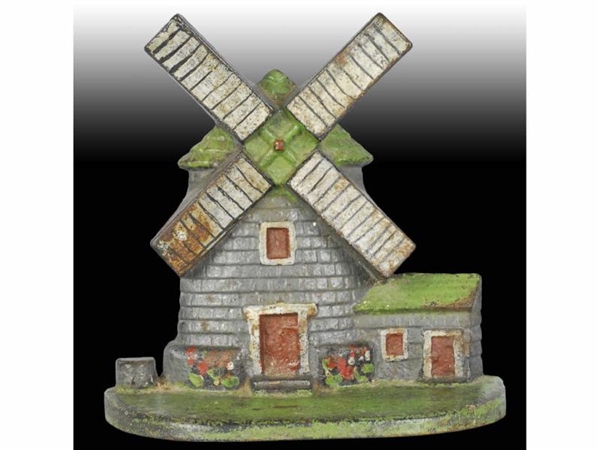 WINDMILL WITH WELL CAST IRON DOORSTOP.            