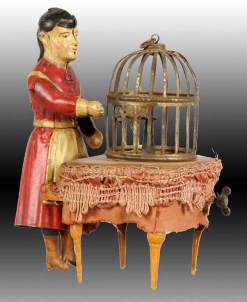 GERMAN HAND-PAINTED TIN WOMAN WITH BIRDCAGE TOY.  