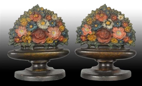 MIXED FLOWERS IN URN CAST IRON BOOKENDS.          