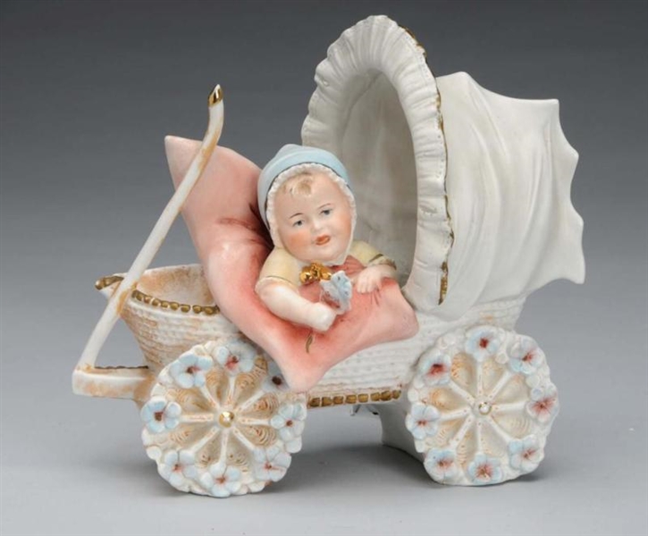 BISQUE FIGURINE OF BABY IN CARRIAGE.              