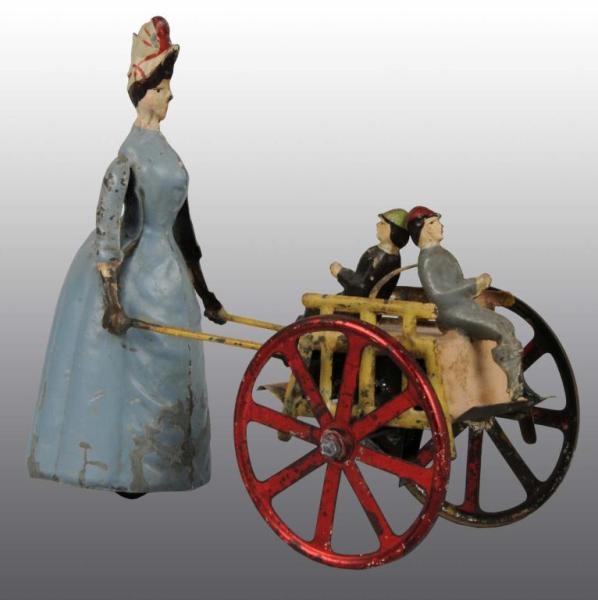 TIN HAND-PAINTED WOMAN PUSHING BOYS IN CART TOY.  