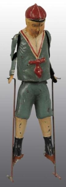 TIN HAND-PAINTED BOY ON STILTS WIND-UP TOY.       