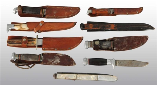 LOT OF 9: KNIVES IN LEATHER SHEATHS.              