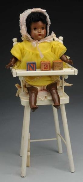 BLACK BABY IN HIGH CHAIR.                         
