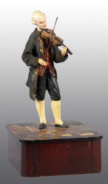 COMPOSITION VIOLIN PLAYER TOY ON BASE.            