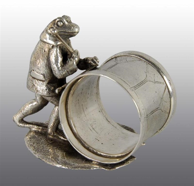 SUITED FROG WITH DRUM STICKS FIGURAL NAPKIN RING. 