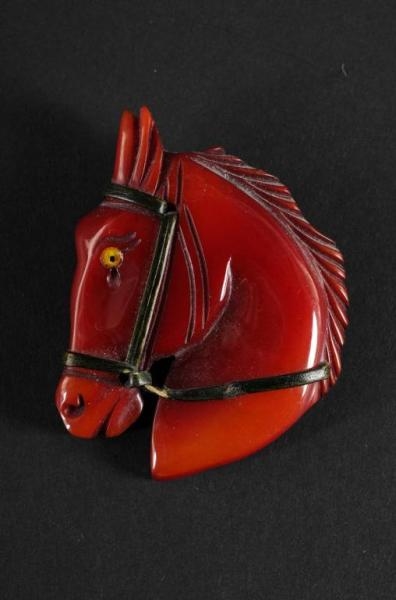 BAKELITE RED HORSE HEAD PIN.                      