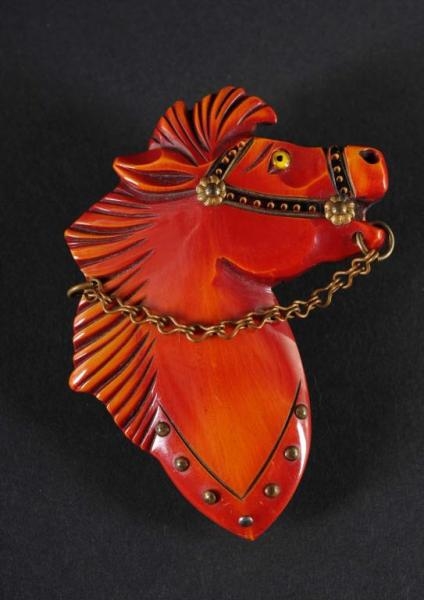 BAKELITE RED HORSE HEAD PIN WITH CHAIN REINS.     
