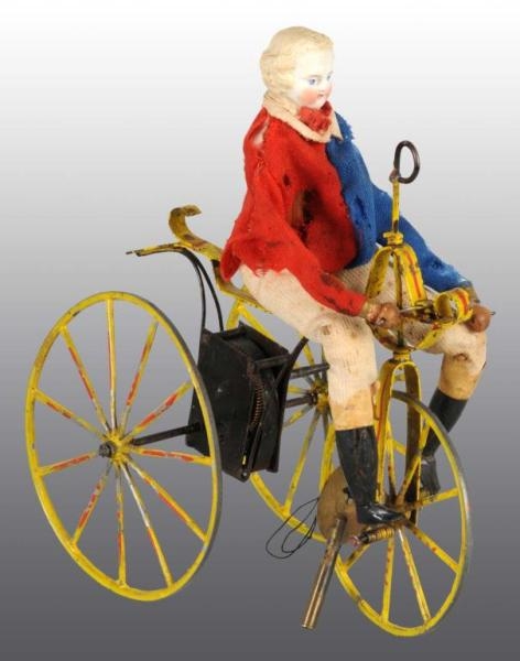 EARLY BISQUE HEAD DOLL ON VELOCIPEDE WIND-UP TOY. 