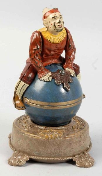 CAST IRON CLOWN ON GLOBE MECHANICAL BANK.         