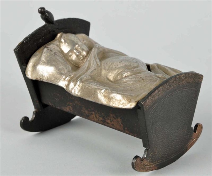 CAST IRON BABY IN CRADLE STILL BANK.              