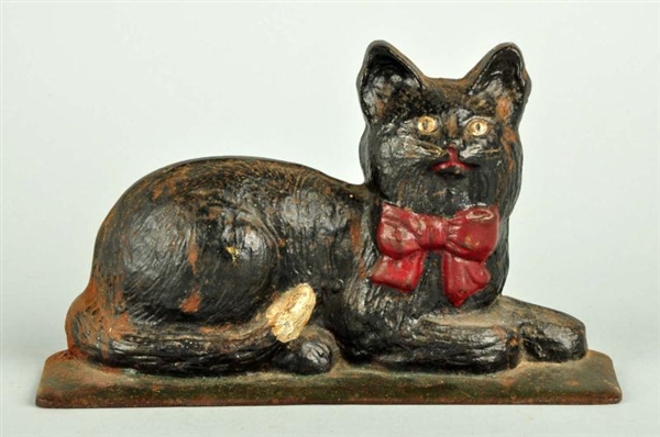 CAST IRON LYING DOWN CAT WITH RED BOW DOORSTOP.   