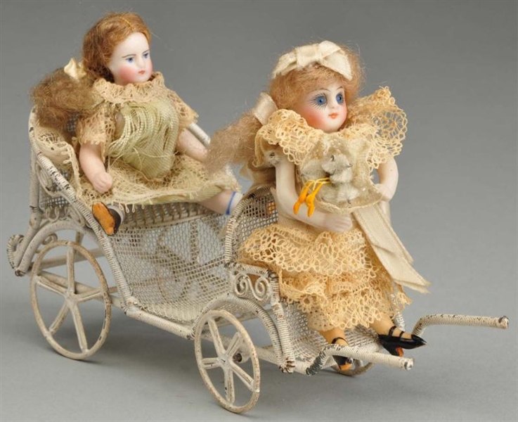 PAIR OF ALL BISQUE DOLLS IN STROLLER.             