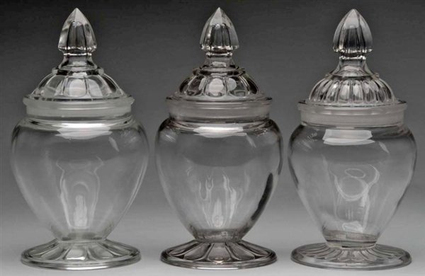 LOT OF 3: CLEAR GLASS TAPERED CANDY JARS.         