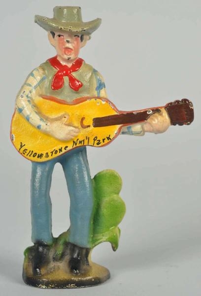 CAST IRON COWBOY WITH GUITAR BOTTLE OPENER.       