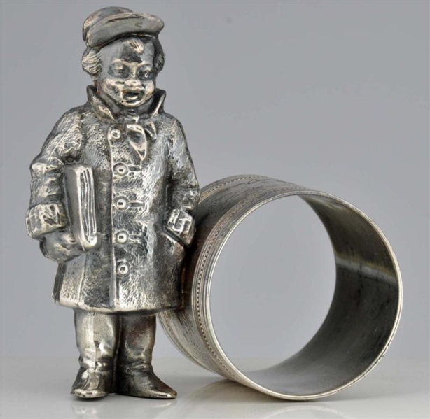 BOY WITH NEWSPAPER STANDING BY NAPKIN RING.       