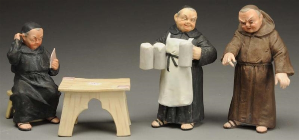 LOT OF 3: MONK FIGURES WITH TABLE.                