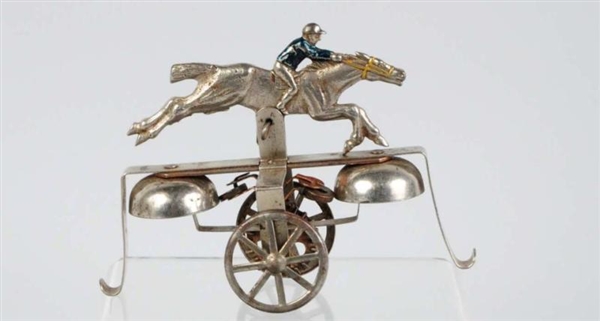 TIN ARTICULATED JOCKEY ON HORSE BELL TOY.         