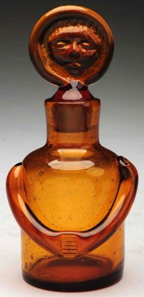 AMBER GLASS BOTTLE WITH AFRICAN AMERICAN STOPPER. 
