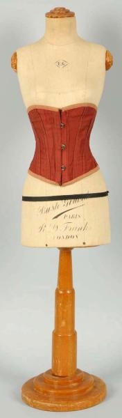 SMALL DRESS FORM ON WOODEN STAND.                 
