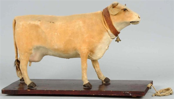 EARLY HIDE-COVERED COW ON PLATFORM TOY.           