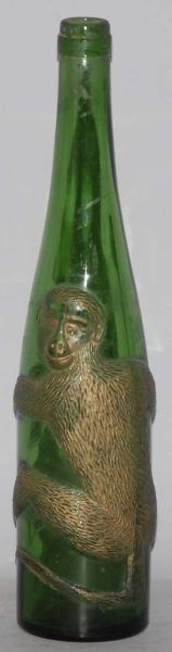 GREEN GLASS BOTTLE WITH EMBOSSED MONKEY.          