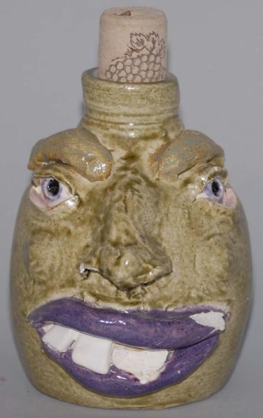 POTTERY GREEN JUG WITH FACE STILL BANK.           