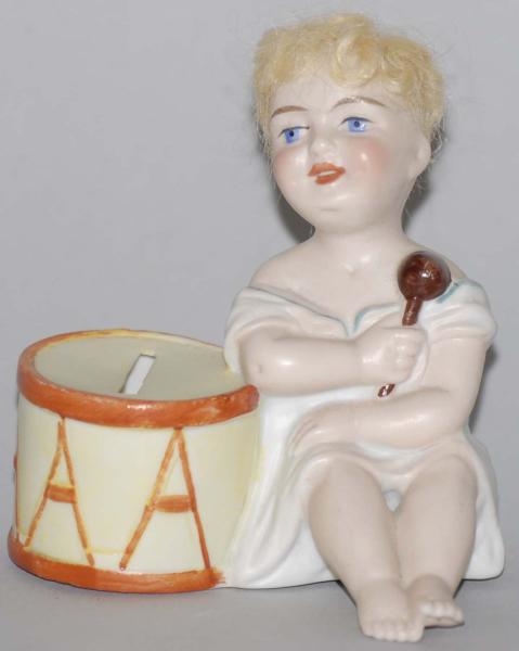 POTTERY GIRL SEATED BY DRUM STILL BANK.           