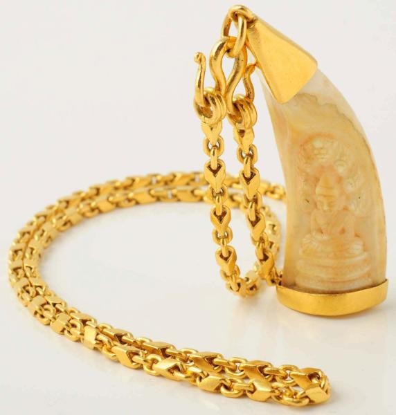 GOLD NECKLACE WITH CARVED TOOTH.                  
