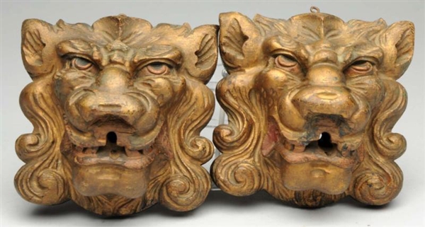 PAIR OF CARVED WOODEN LION HEADS.                 