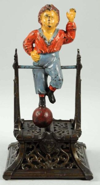 CAST IRON BOY ON TRAPEZE MECHANICAL BANK.         