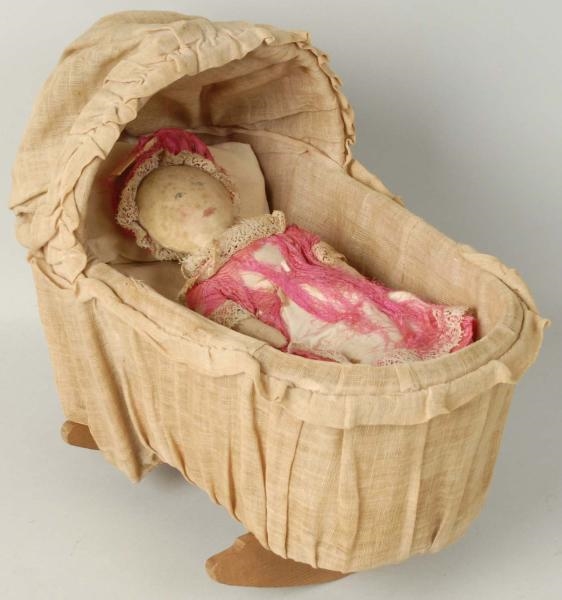 SMALL PINK CLOTH DOLL IN BASSINET.                