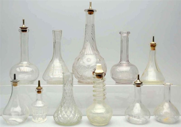 LOT OF 11: ASSORTED CLEAR GLASS BOTTLES.          