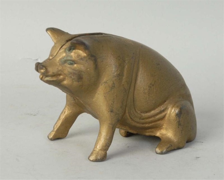 CAST IRON GOLDEN SITTING PIG STILL BANK.          